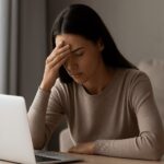 „Unavený mladý človek pred obrazovkou – vizuálne vyjadrenie digitálnej únavy po príliš veľa online čase.”